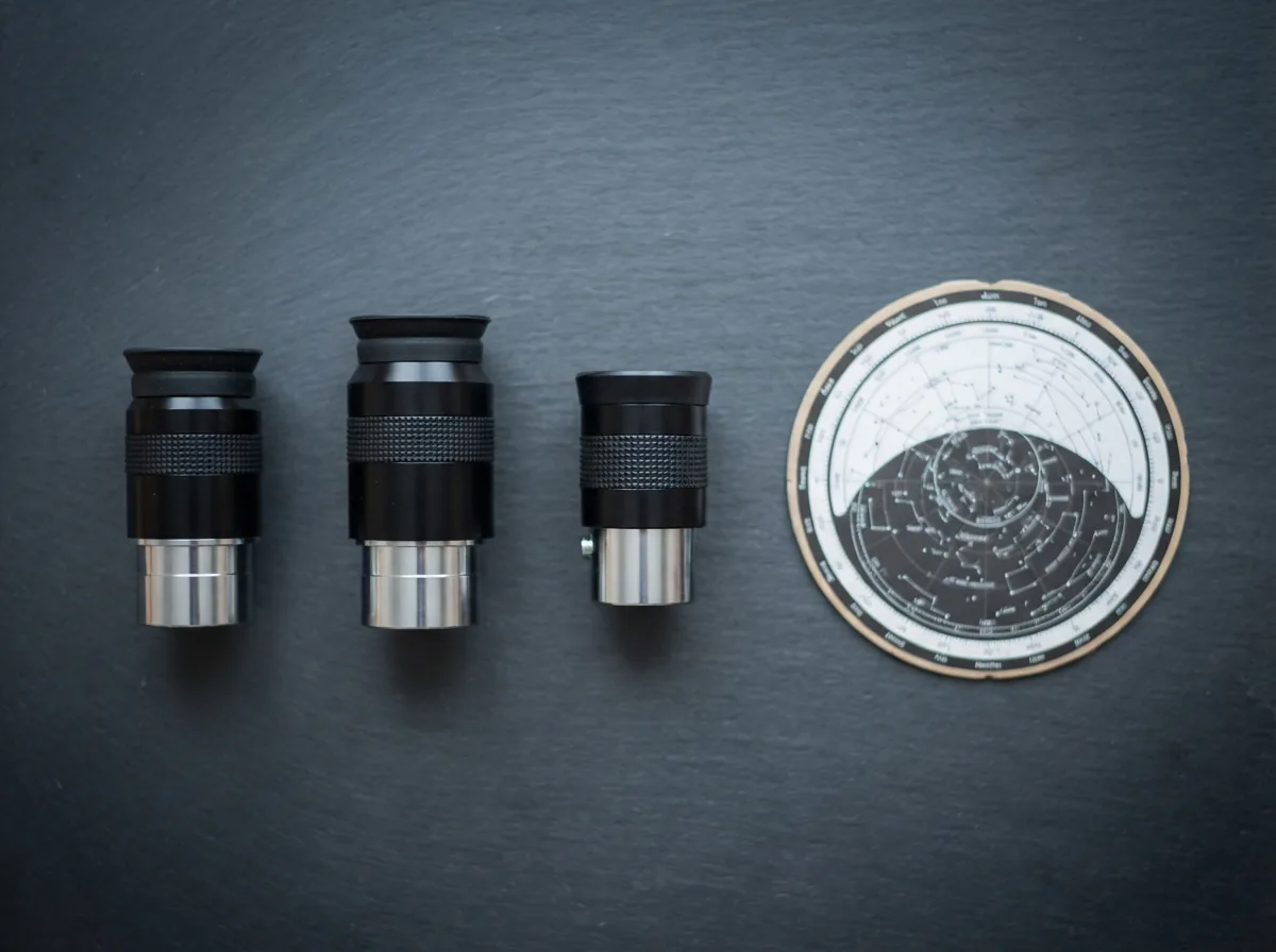 The included accessories of the Orion StarBlast II kit: two eyepieces, a Barlow lens, and the planisphere.